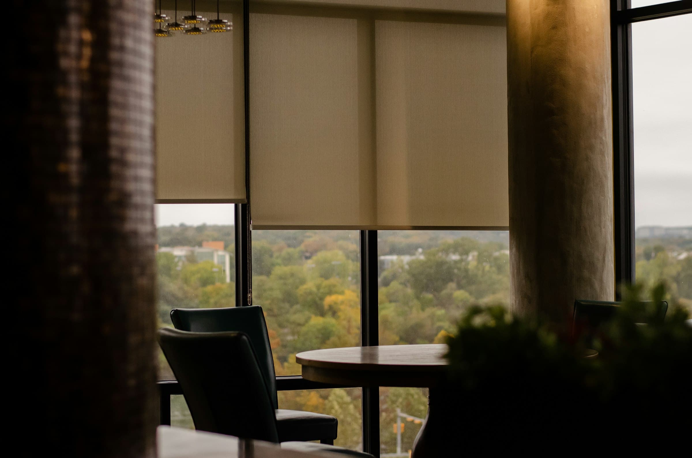 Fabric roller blinds lowered to different heights across a large opening